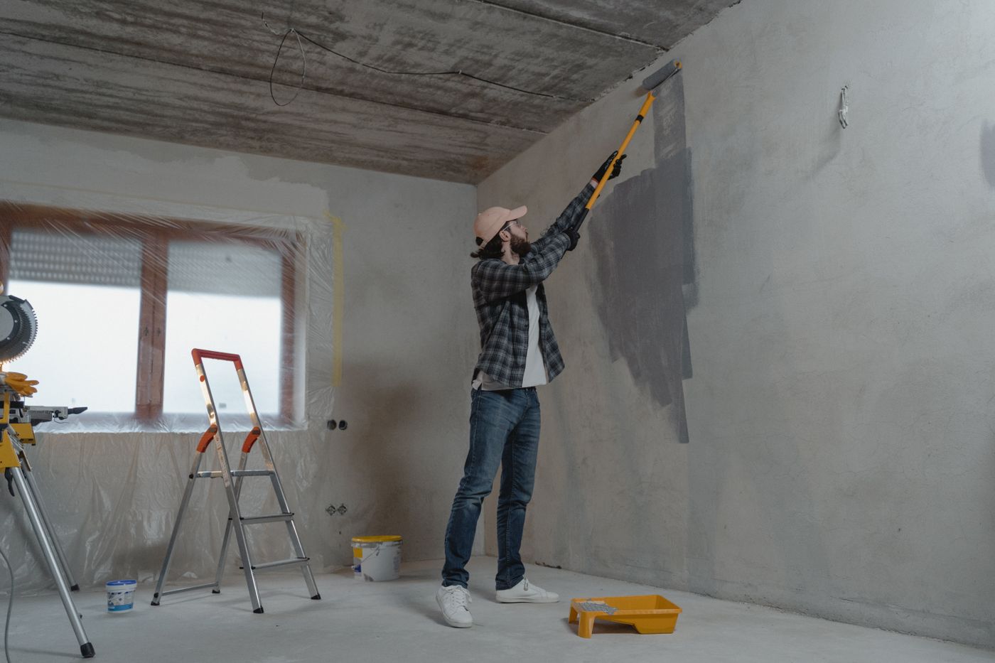 A Mid Hudson Painters crew member spray-painting a wall during an interior repaint