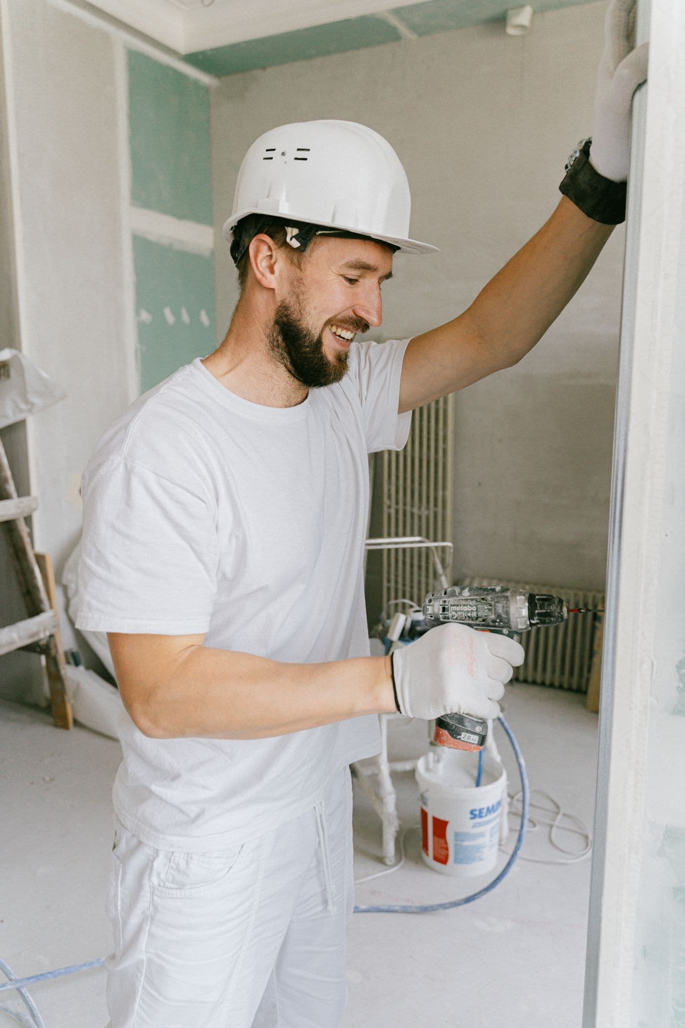 The owner of Mid Hudson Painters in painter's whites with a bucket on a job site in Orange County NY