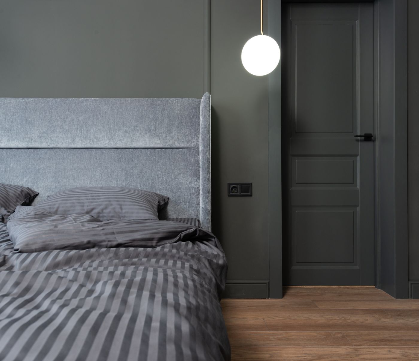 Charcoal-gray bedroom wall repaint with crisp white bedding in Monroe NY